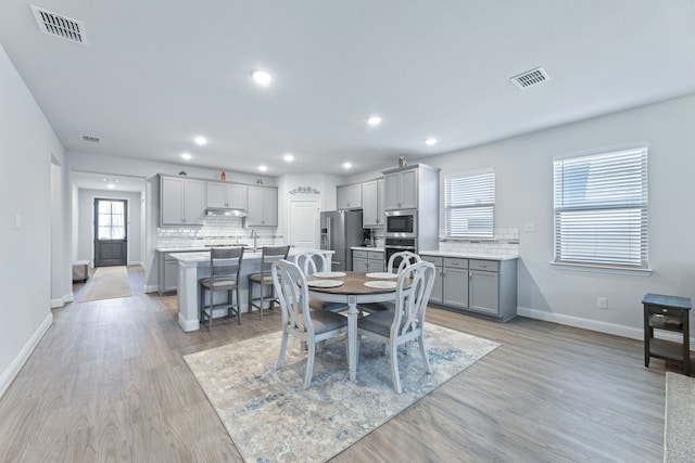 dining room featuring light wood-type flooring and sink