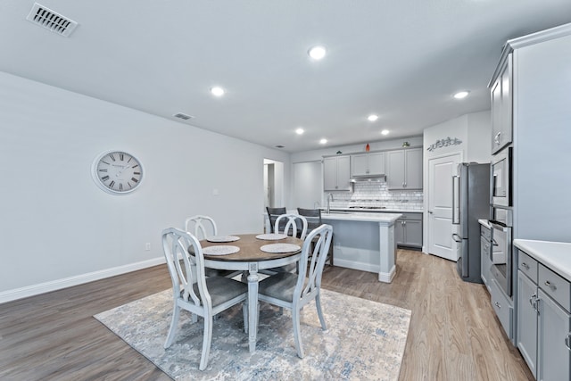 dining space featuring light hardwood / wood-style flooring and sink