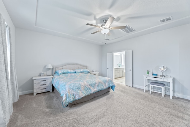 bedroom featuring connected bathroom, ceiling fan, and light colored carpet