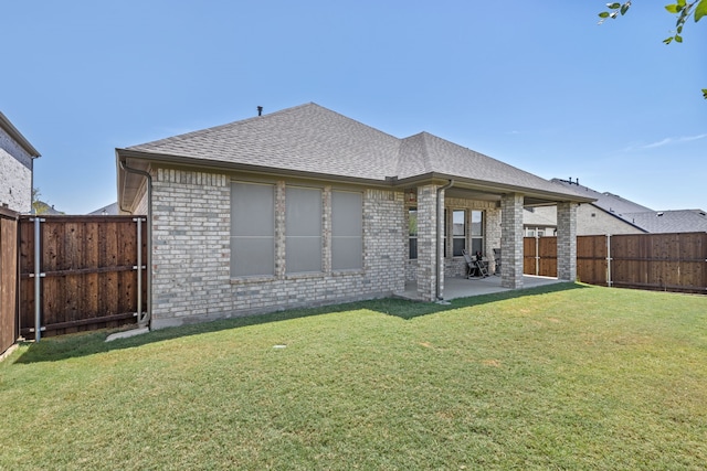 rear view of property featuring a patio and a lawn