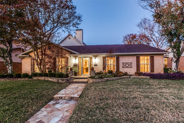 ranch-style home featuring a lawn