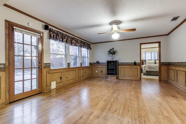 unfurnished office featuring ceiling fan, ornamental molding, and light hardwood / wood-style floors