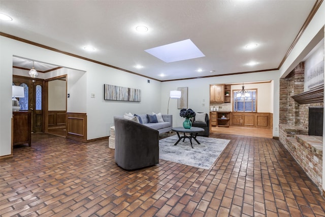 living room featuring a skylight, crown molding, a fireplace, and a textured ceiling