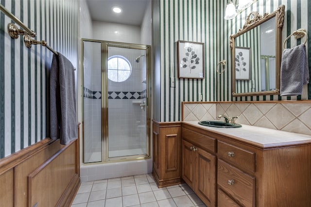 bathroom with backsplash, tile patterned flooring, vanity, and walk in shower