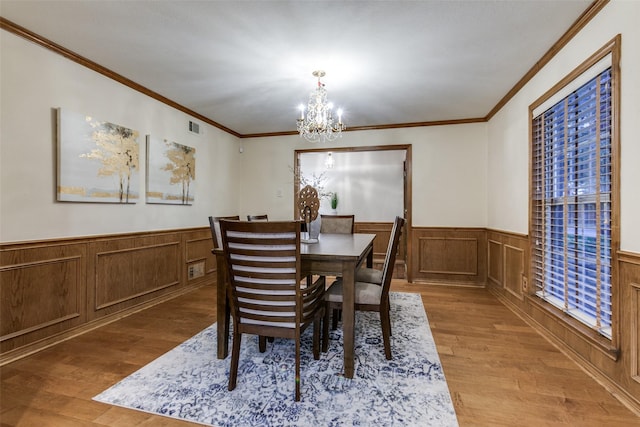 dining space with a chandelier, hardwood / wood-style flooring, and crown molding