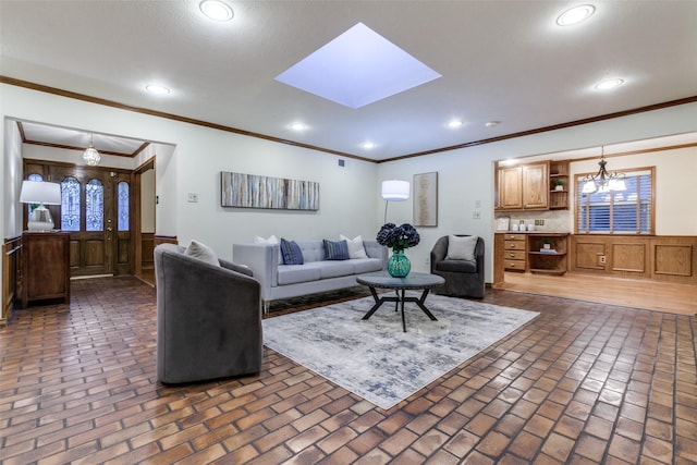 living room with ornamental molding and a skylight