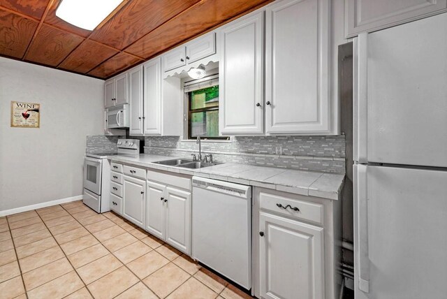 kitchen with white cabinetry, white appliances, and tasteful backsplash