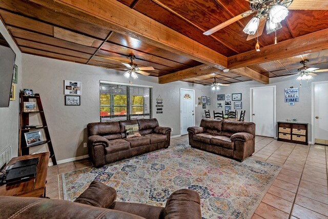 living room featuring beam ceiling, light tile patterned flooring, ceiling fan, and wood ceiling