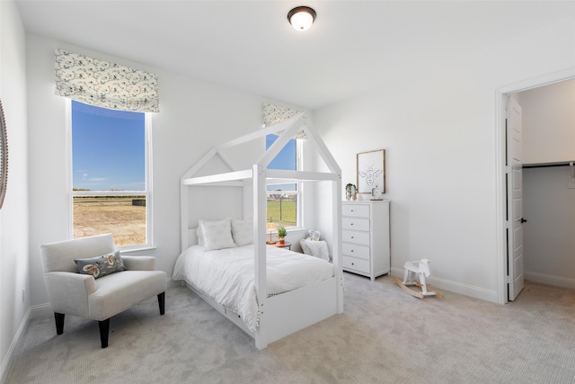 bedroom featuring light colored carpet and multiple windows