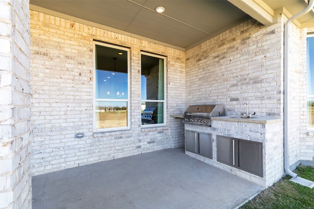 view of patio / terrace with an outdoor kitchen, area for grilling, and sink