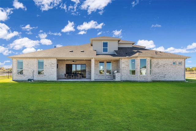 rear view of property featuring a lawn, a patio area, and ceiling fan