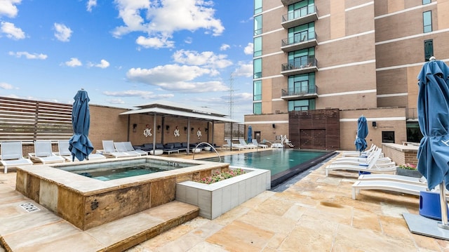 view of swimming pool with a patio and a hot tub