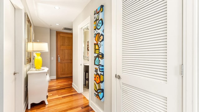 hallway with recessed lighting, visible vents, light wood-style flooring, and baseboards