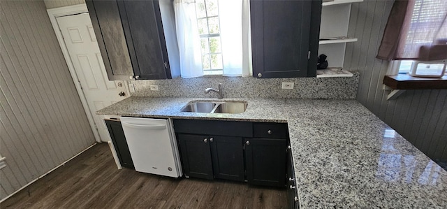 kitchen featuring dark wood-type flooring, dishwasher, sink, and light stone countertops