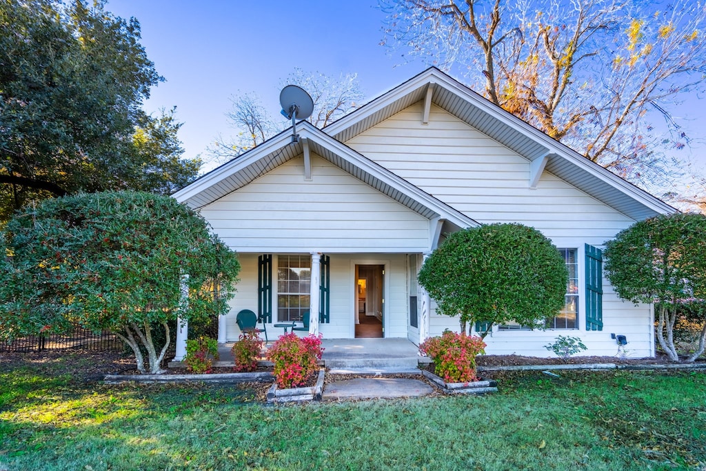 bungalow-style home with a front lawn and covered porch