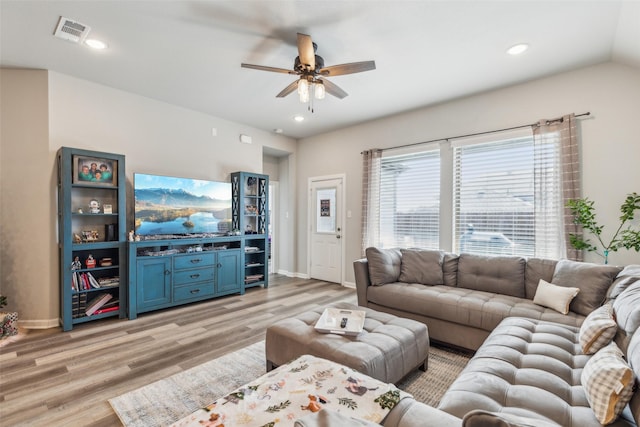 living room featuring ceiling fan, vaulted ceiling, and light wood-type flooring