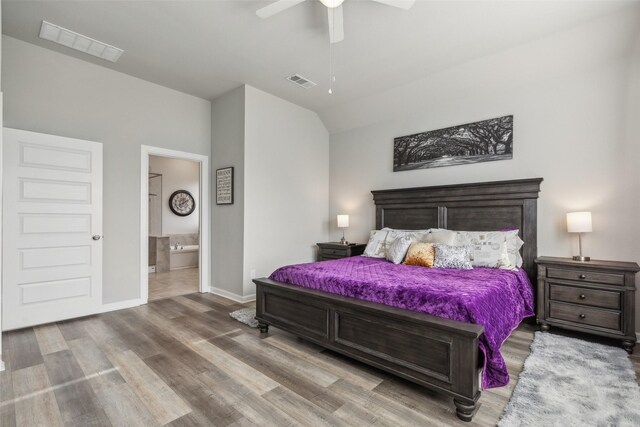 bedroom with hardwood / wood-style floors, ensuite bathroom, vaulted ceiling, and ceiling fan