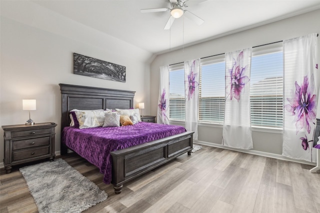 bedroom featuring hardwood / wood-style floors, ceiling fan, and multiple windows