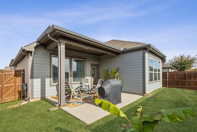 back of property with a yard and a patio