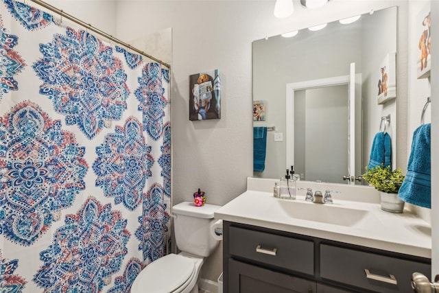 bathroom featuring a shower with curtain, vanity, and toilet