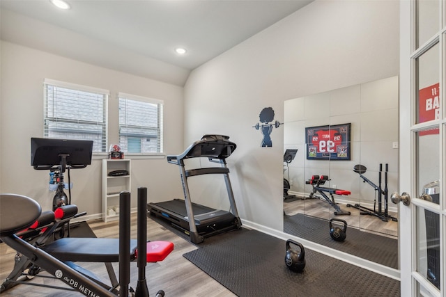 exercise room featuring hardwood / wood-style flooring and lofted ceiling