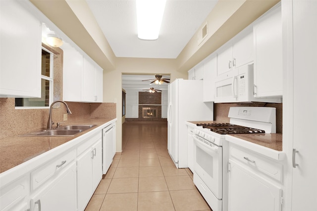 kitchen with white appliances, white cabinetry, and sink