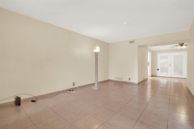 tiled empty room featuring ceiling fan