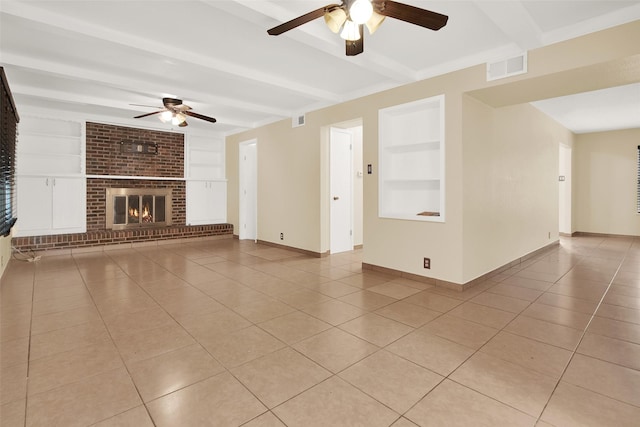 unfurnished living room with built in shelves, beamed ceiling, and light tile patterned floors