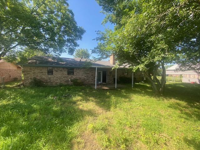 rear view of property with a lawn