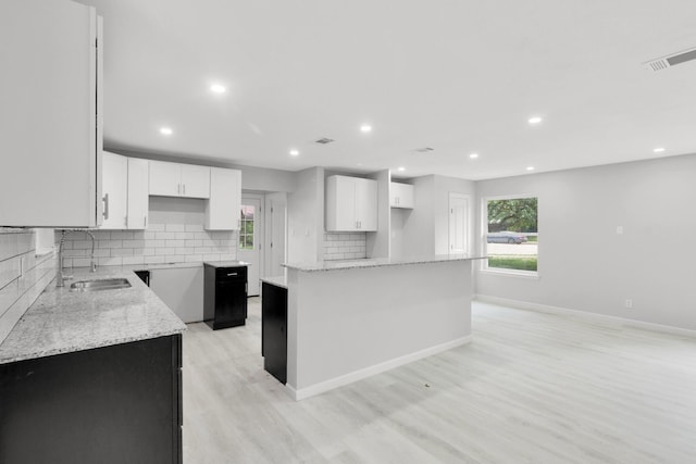 kitchen featuring white cabinets, tasteful backsplash, a kitchen island, and sink