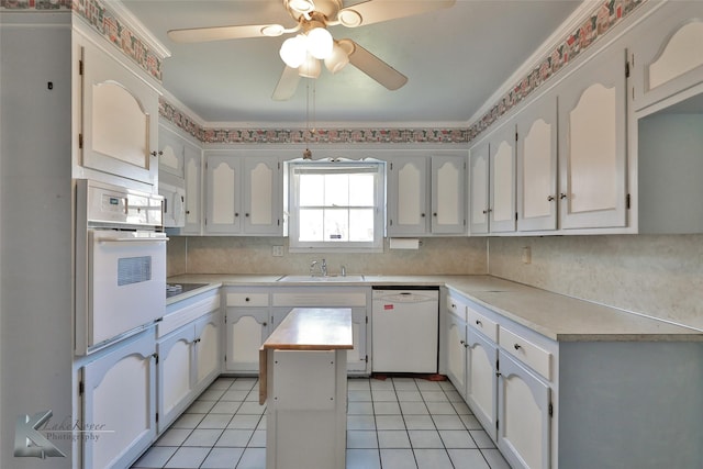 kitchen featuring sink, white cabinetry, tasteful backsplash, a center island, and white appliances