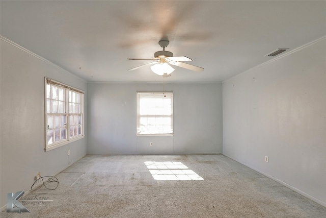 spare room featuring crown molding, light colored carpet, and ceiling fan