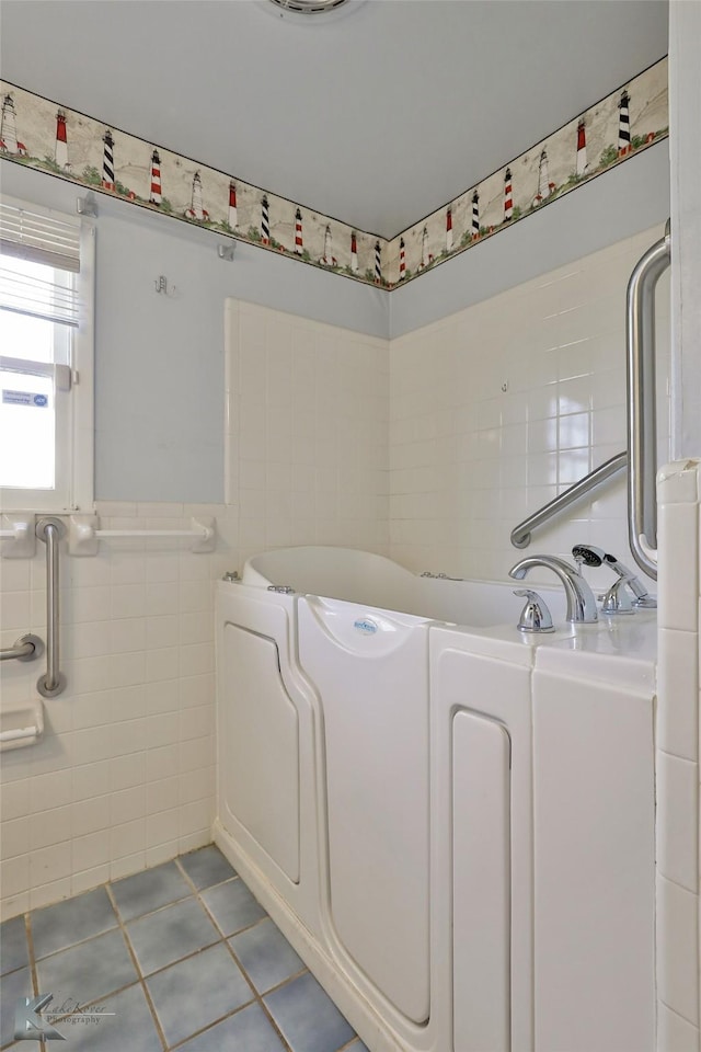 bathroom featuring tile patterned flooring, tile walls, and a washtub