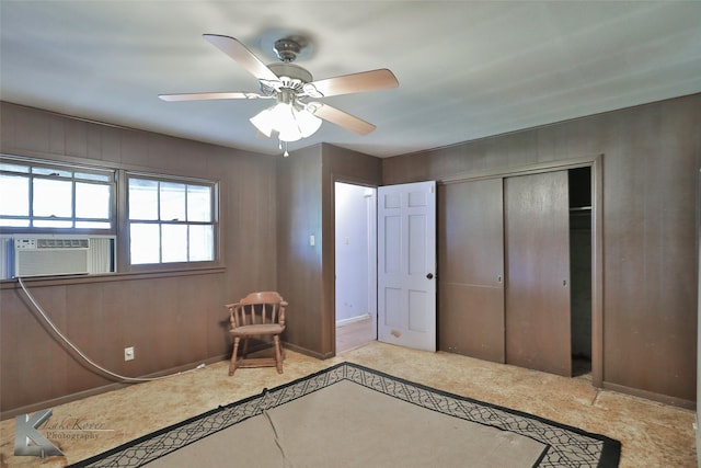 unfurnished bedroom with cooling unit, light colored carpet, a closet, and ceiling fan