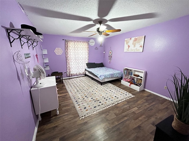 bedroom with ceiling fan, dark wood-type flooring, and a textured ceiling