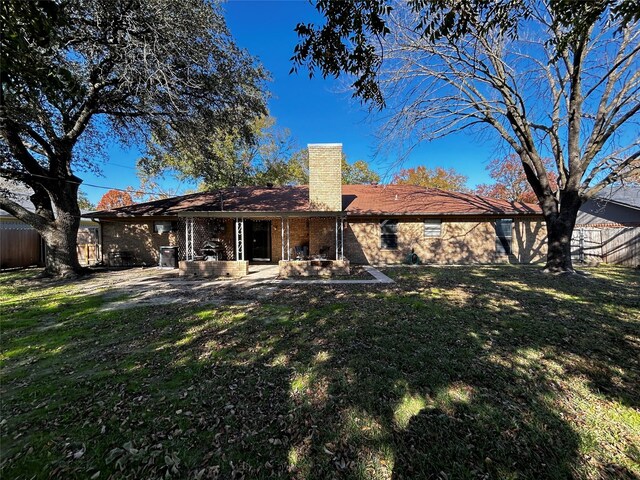 rear view of property featuring a lawn and a patio