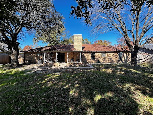 rear view of property featuring a patio area and a lawn