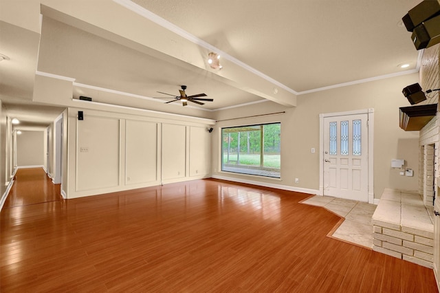 unfurnished living room with ornamental molding, ceiling fan, and light wood-type flooring