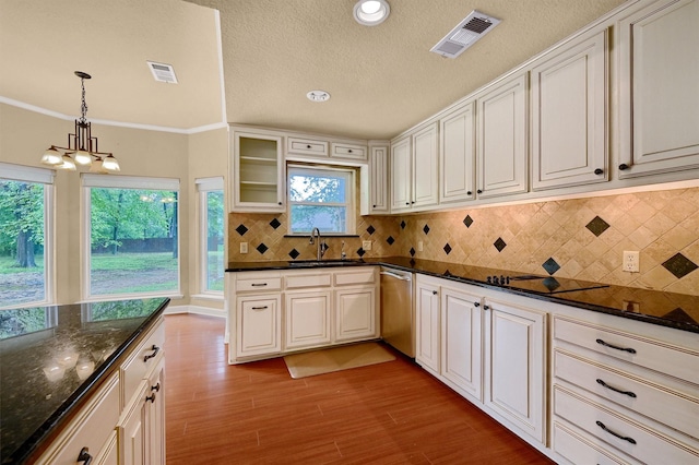 kitchen with sink, light wood-type flooring, dark stone countertops, dishwasher, and pendant lighting