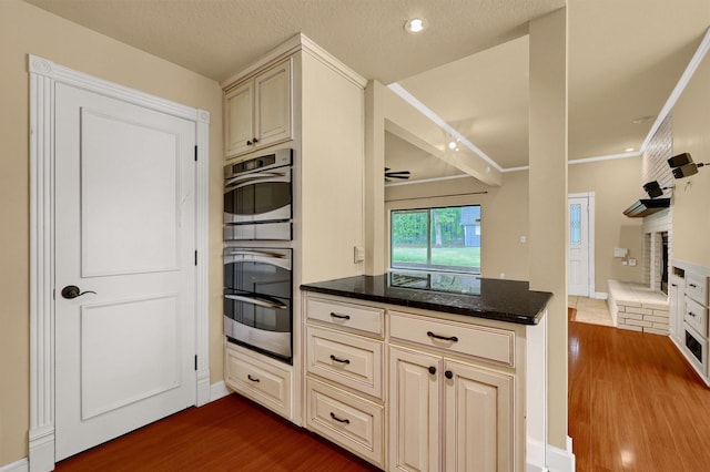 kitchen with dark hardwood / wood-style flooring, cream cabinets, and a textured ceiling