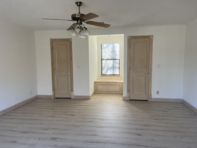 unfurnished room with ceiling fan, a textured ceiling, and light wood-type flooring