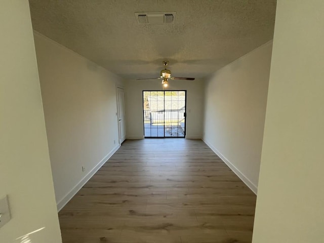 spare room with ceiling fan, a textured ceiling, and light hardwood / wood-style floors