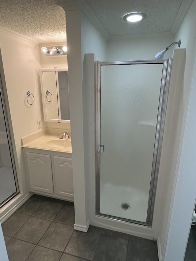 bathroom with vanity, tile patterned flooring, a shower with door, and a textured ceiling