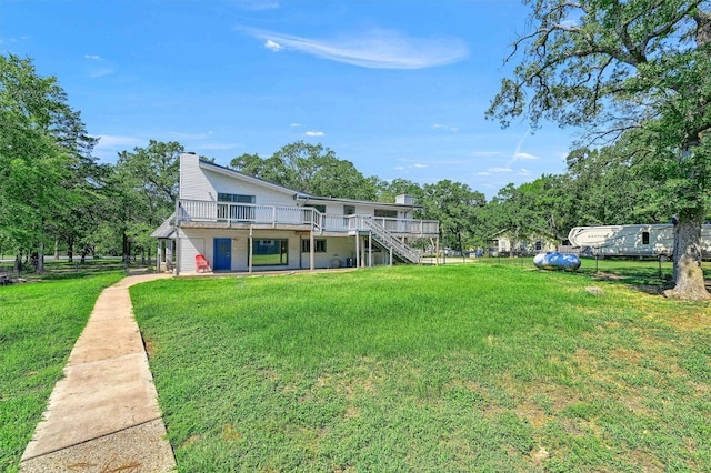 rear view of property featuring a yard and a deck