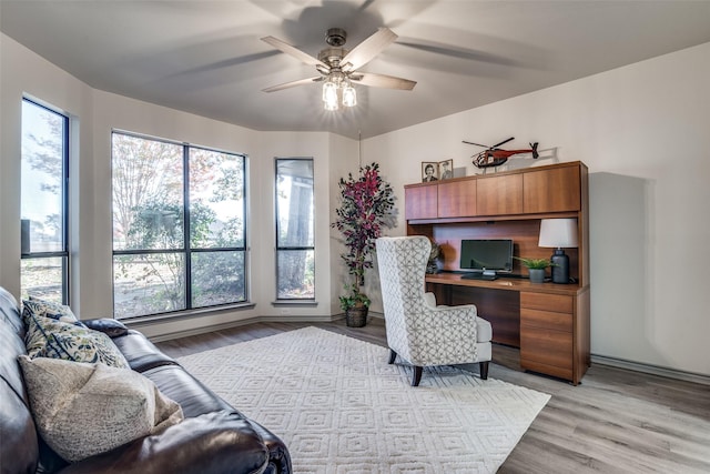 home office featuring ceiling fan and light hardwood / wood-style flooring