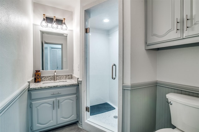 bathroom featuring vanity, toilet, and an enclosed shower