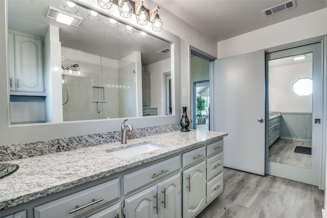 bathroom with vanity, wood-type flooring, and a shower with door