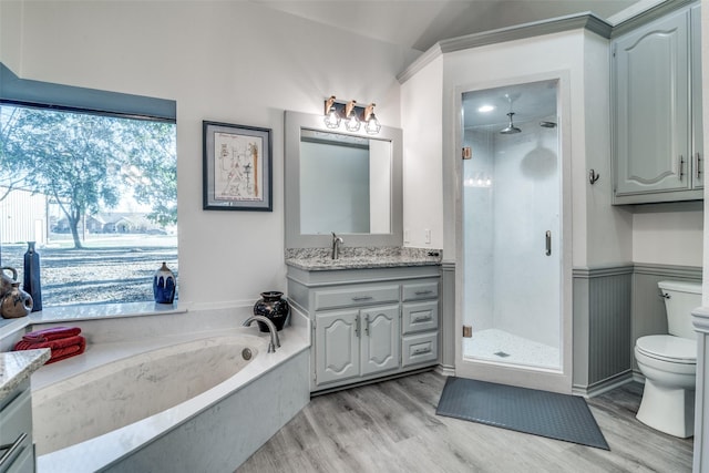 full bathroom featuring vanity, hardwood / wood-style floors, toilet, and separate shower and tub