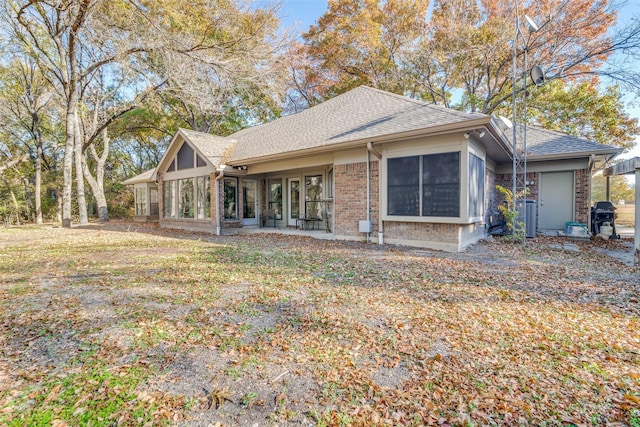 rear view of property featuring central AC unit and a lawn