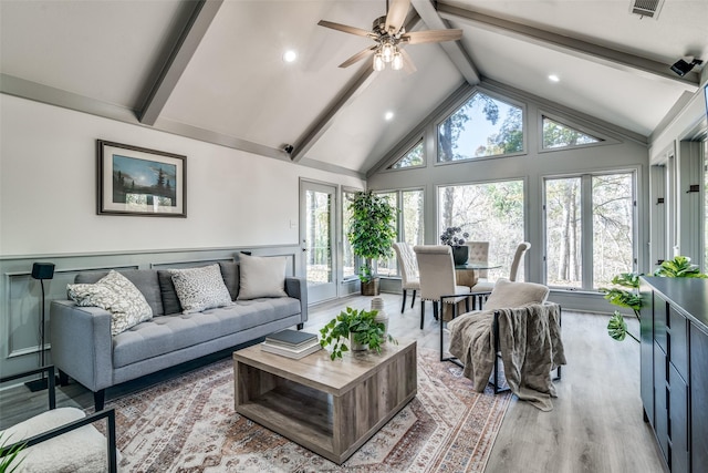 living room featuring beam ceiling, light hardwood / wood-style flooring, high vaulted ceiling, and ceiling fan